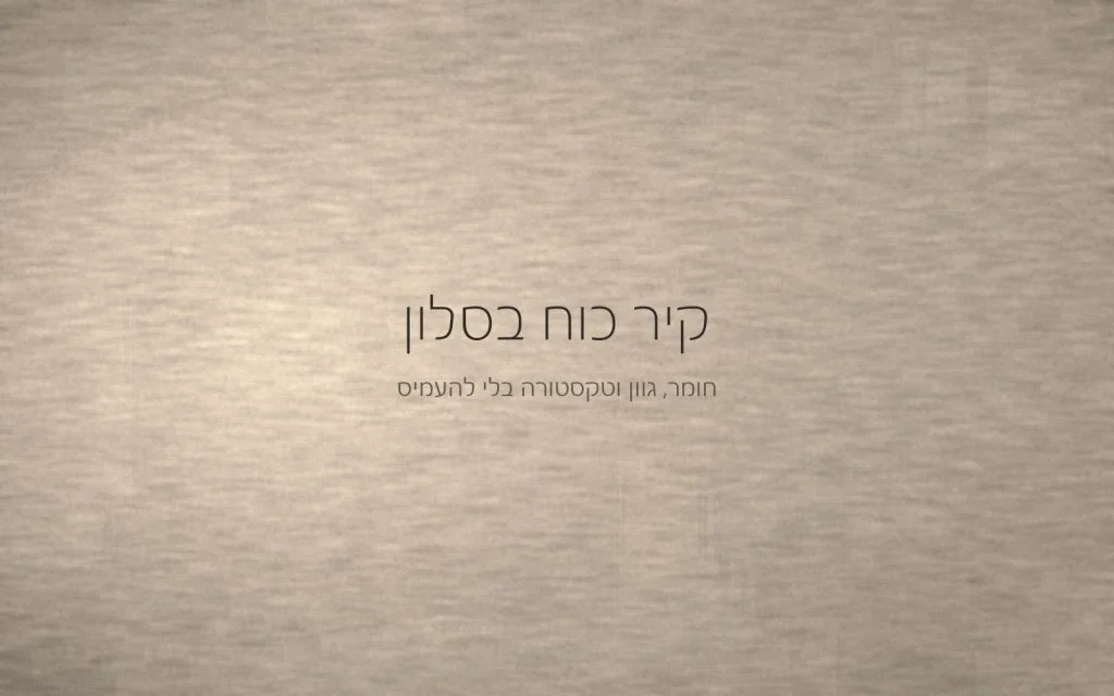 קיר בטיח מינרלי בגוון חול חמים עם משיכות מאלג רחבות, מואר באור צד שמדגיש את המרקם