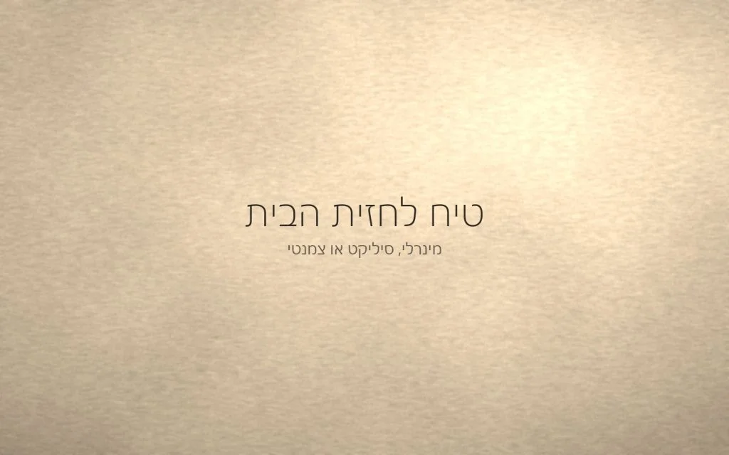 קיר חוץ בטיח מינרלי בגוון חול, עם צל רך של אור שמש נמוך